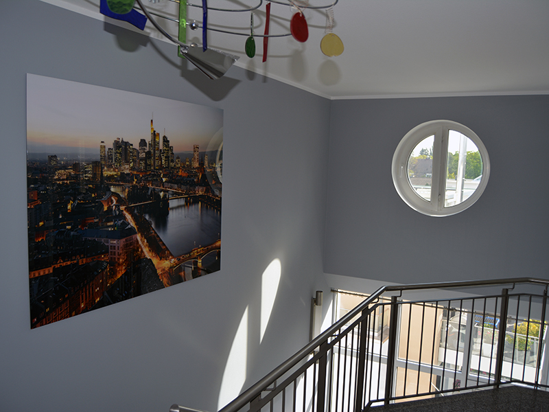 grauer Flur mit Treppe, moderne Deckenlampe und Wandfoto 